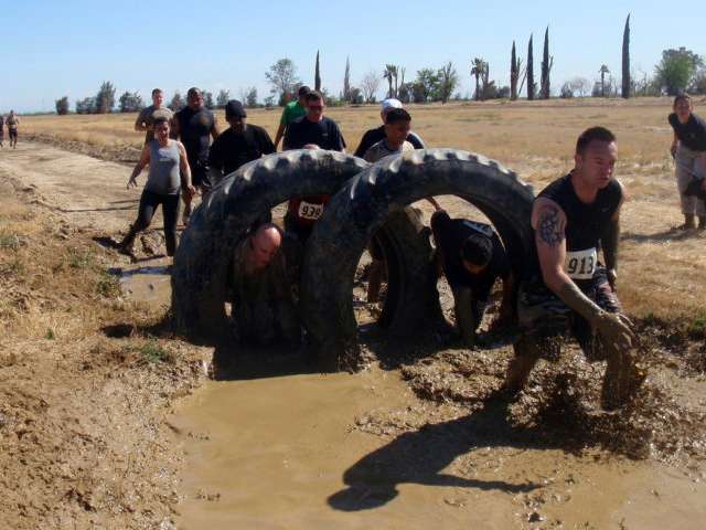 Climbing through tires as obstacles on the mud run. 