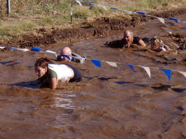 A mud pit with some obstacles at the mud run. 