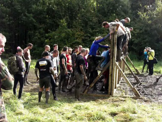 There are plenty of people there to lend a helping hand - if you need it - when climbing walls on a mud run. 